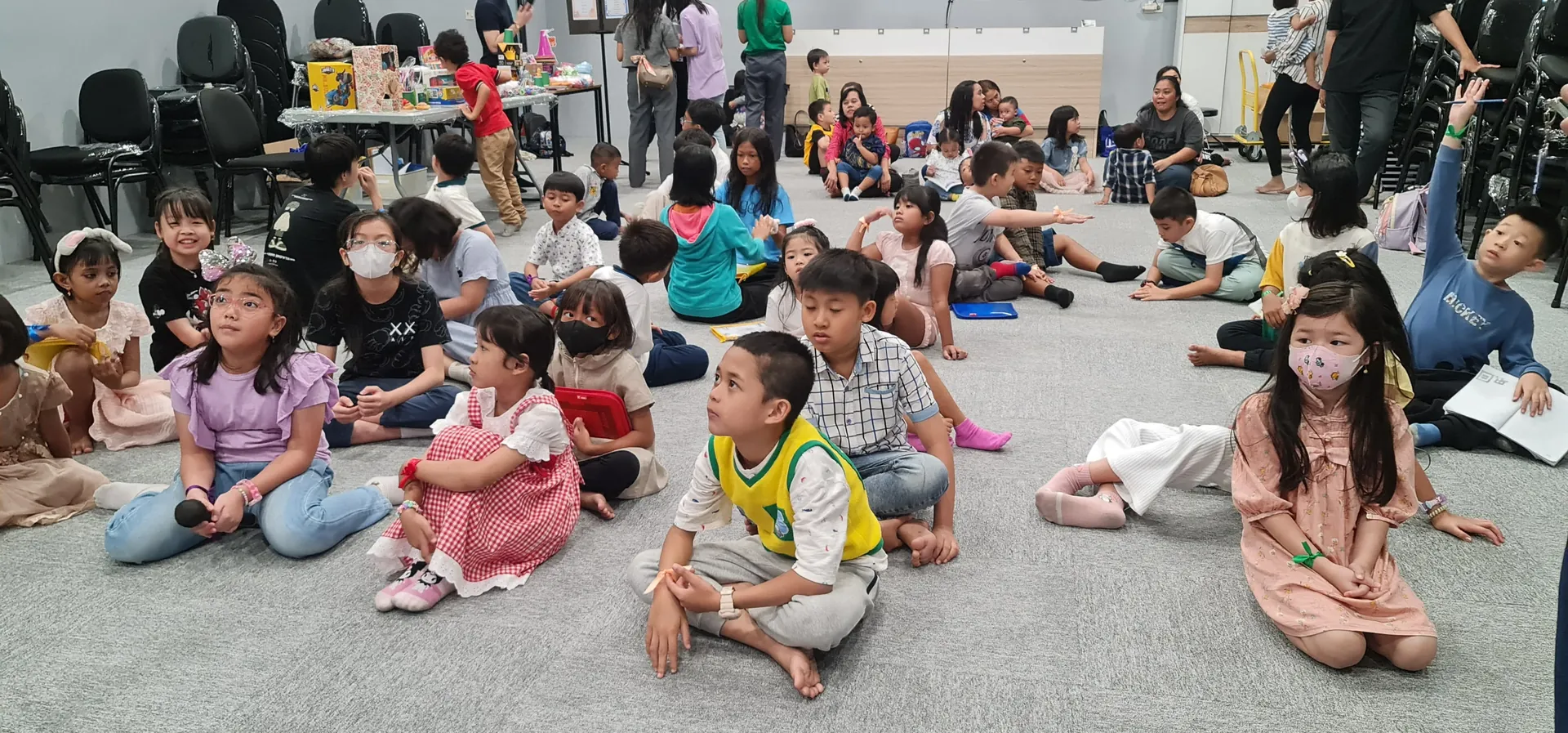 Anak-anak Sekolah Minggu duduk bersama di hall
