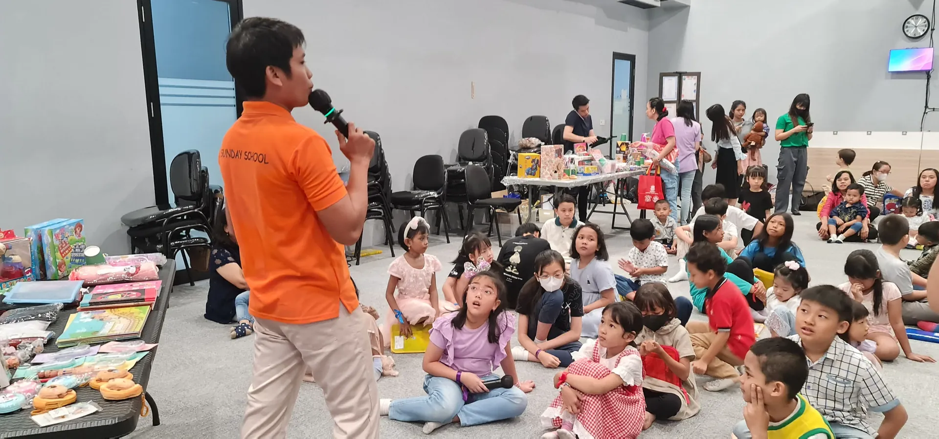 Kakak pelayan Sekolah Minggu memegang mic