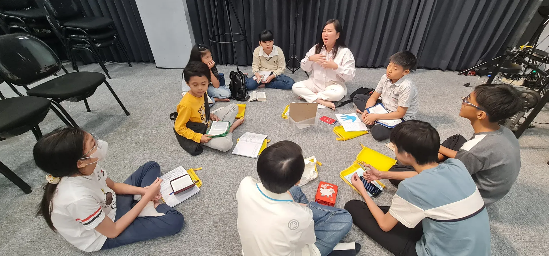 Anak-anak Sekolah Minggu duduk lingkaran bersama guru