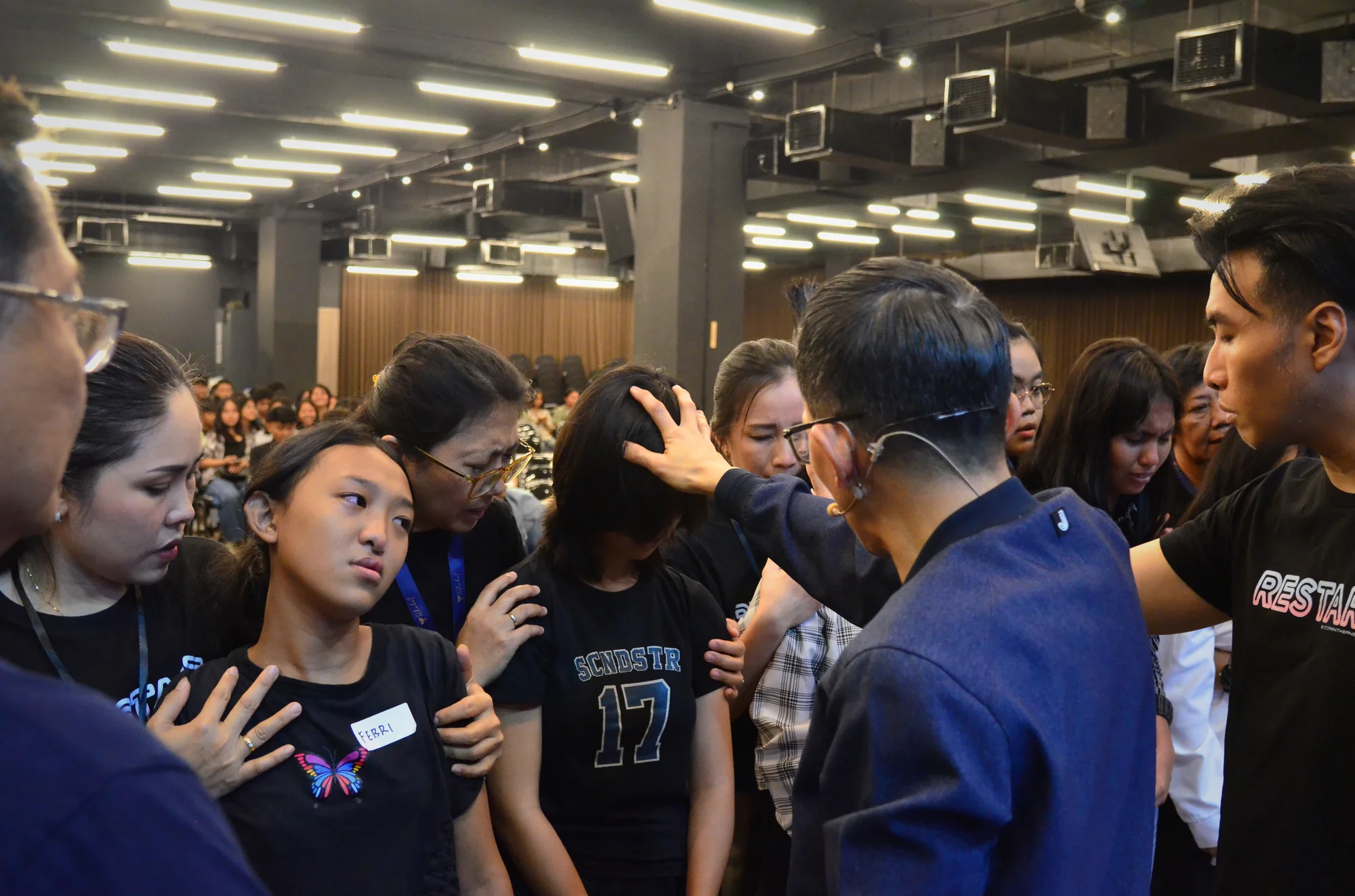 Pendeta mendoakan pemuda dengan tangan di kepala