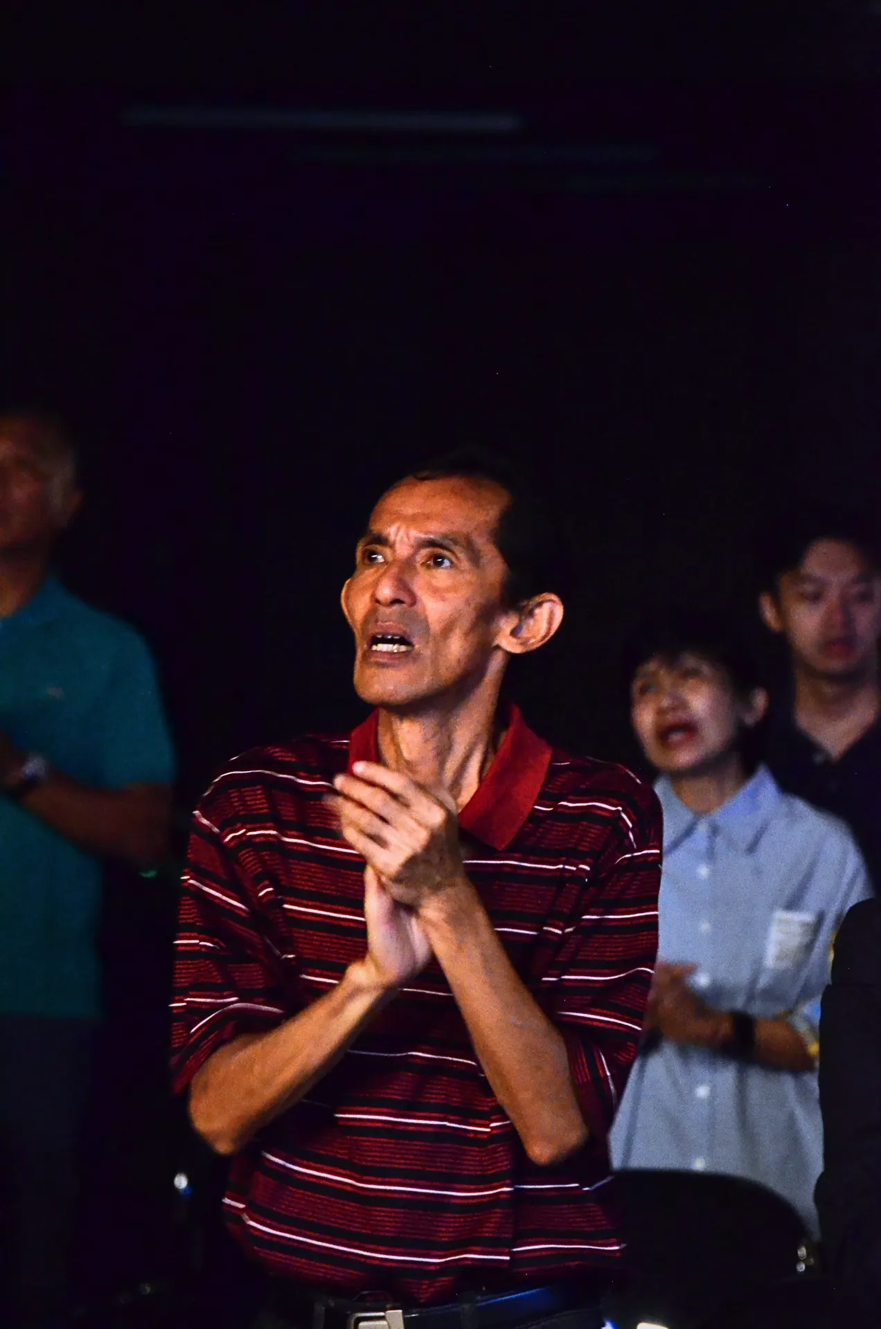 Bapak berbaju merah memandang dalam pujian