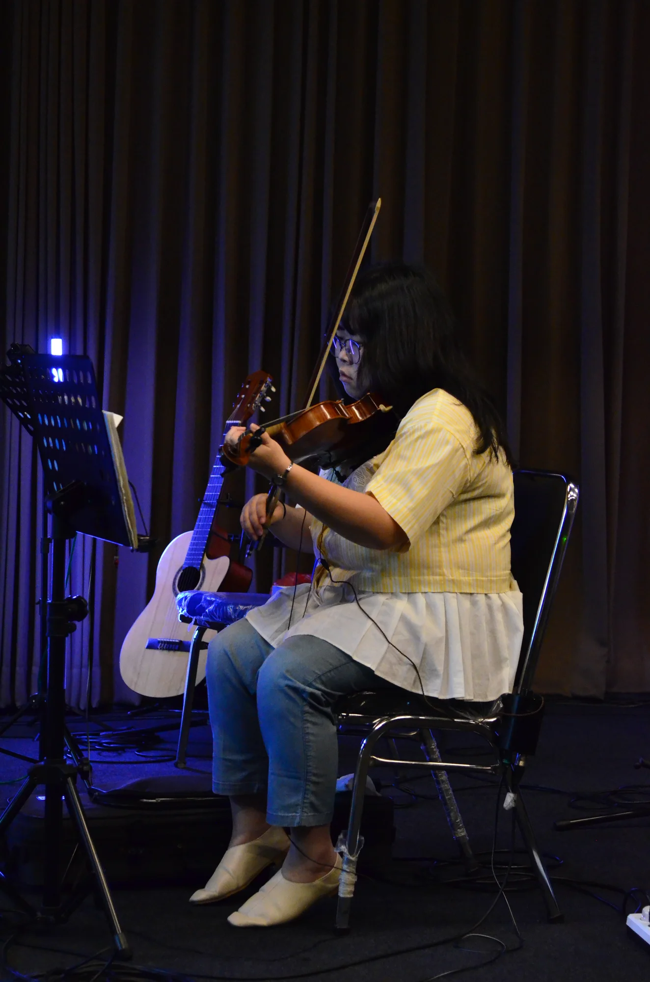 Violinis wanita yellow stripe bermain biola di stage